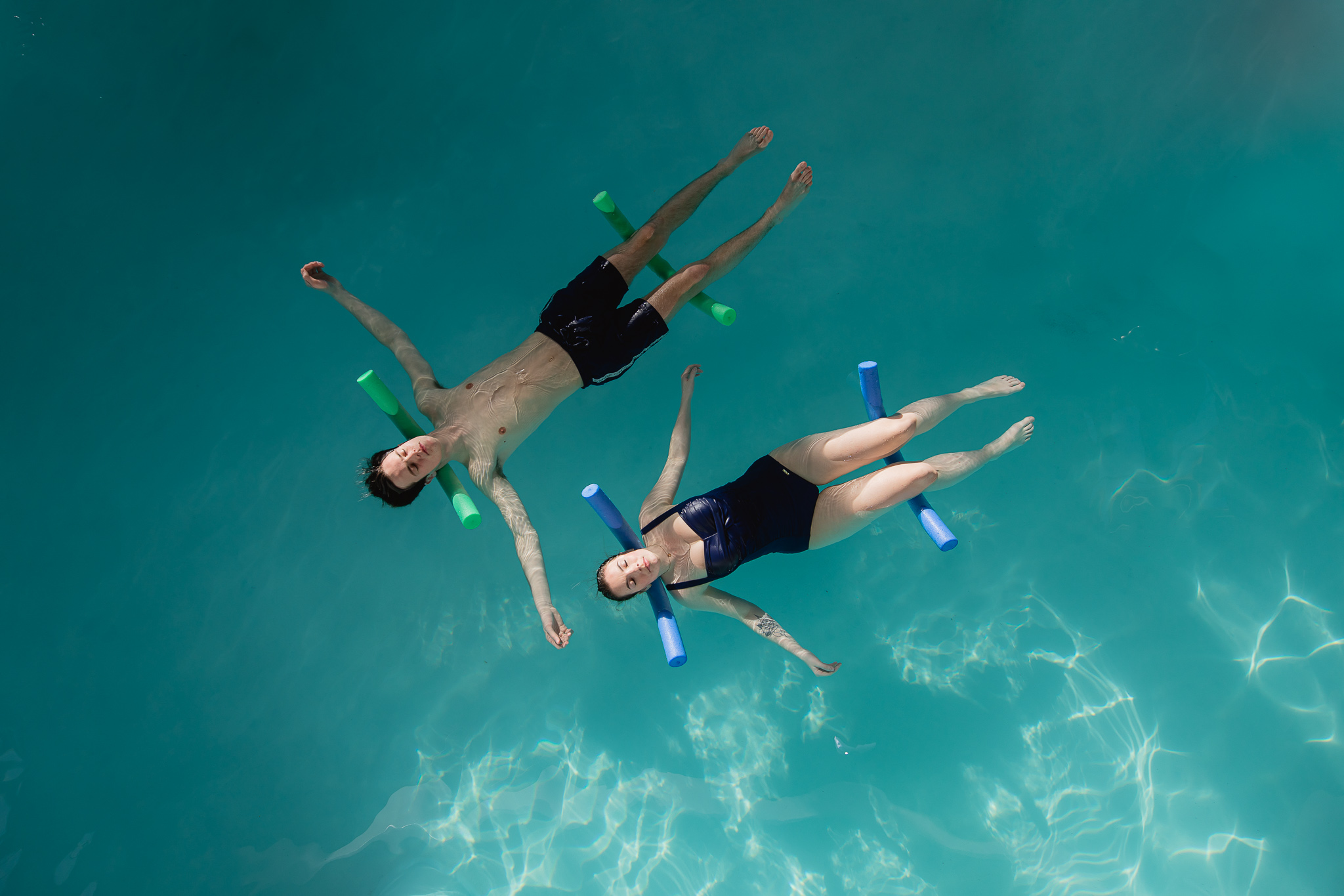 Koppel is aan het drijven in thermaal water op foam rollers, tijdens sessie floating.