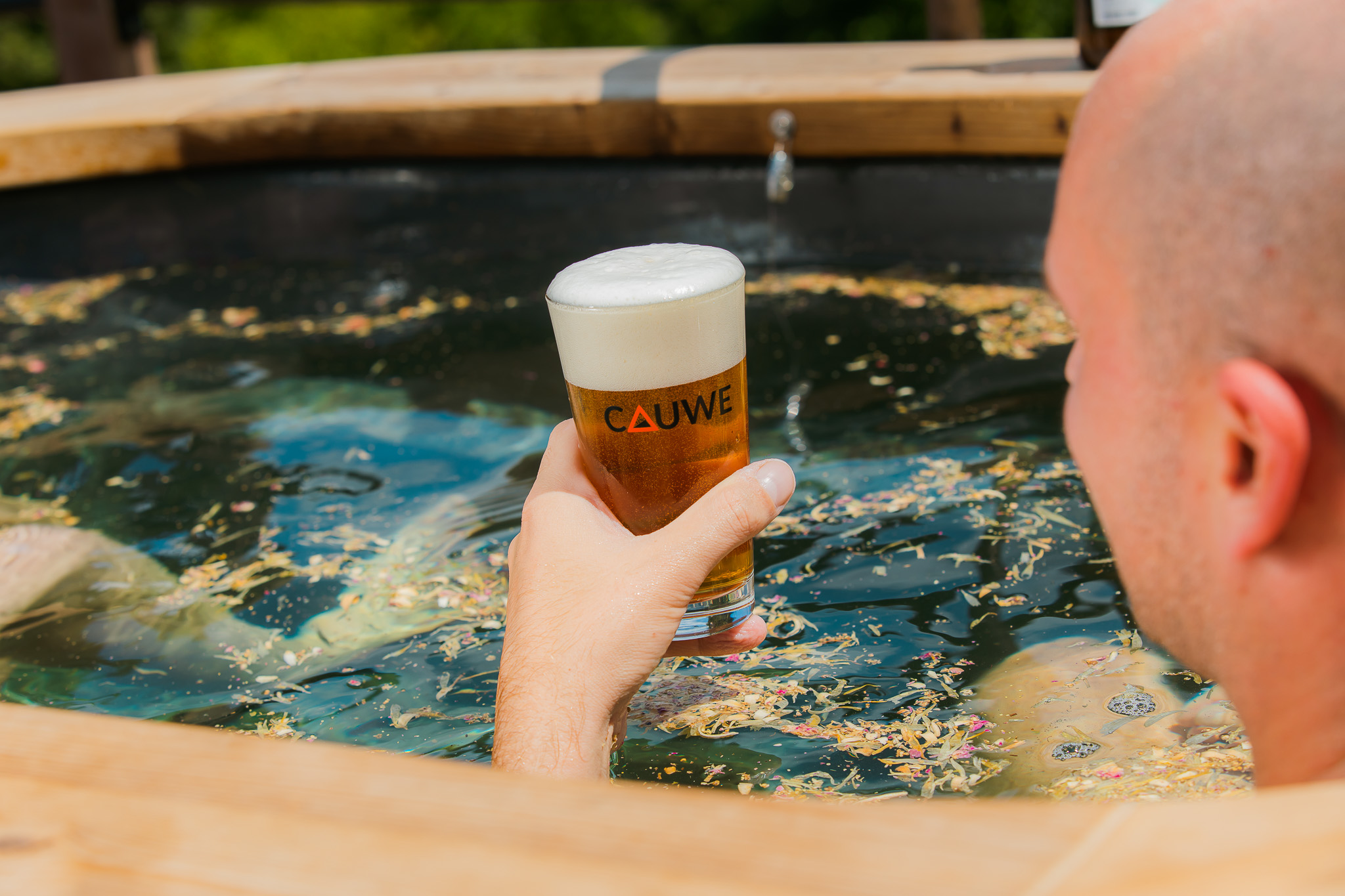 Man geniet van Cauwe biertje tijdens de bierbad wellness ervaring.